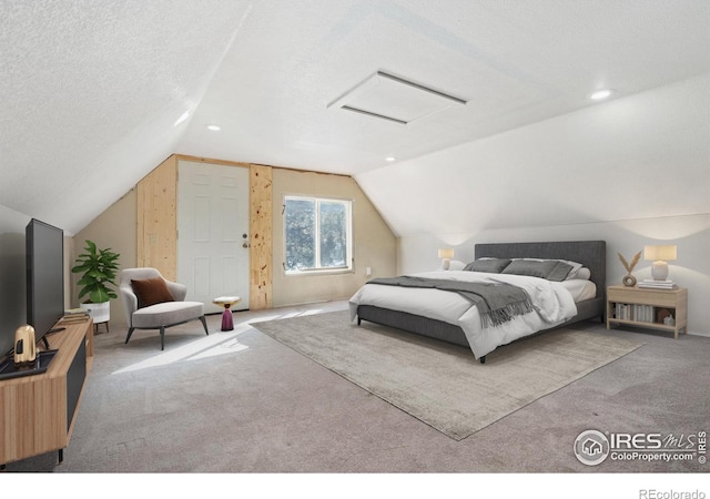 bedroom with lofted ceiling, carpet floors, and a textured ceiling