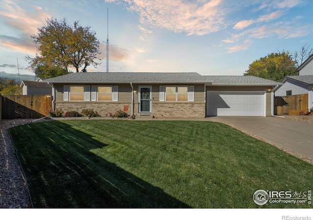 single story home with a garage and a lawn