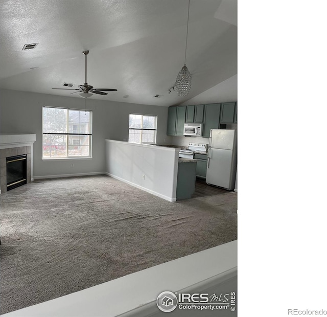 kitchen with white appliances, ceiling fan, carpet, a fireplace, and vaulted ceiling