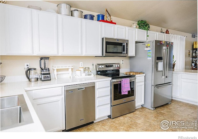 kitchen featuring sink, a textured ceiling, stainless steel appliances, and white cabinets