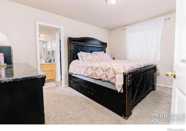 bedroom with light colored carpet and ensuite bath