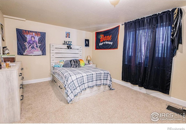 bedroom with light colored carpet and a textured ceiling