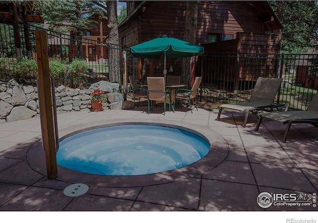 view of swimming pool featuring an in ground hot tub and a patio