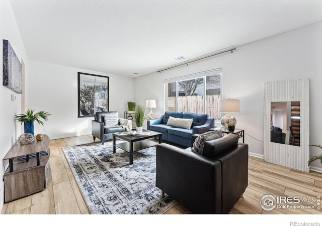 living room with light hardwood / wood-style flooring and a textured ceiling