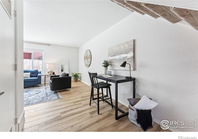 office area with light hardwood / wood-style floors and beamed ceiling