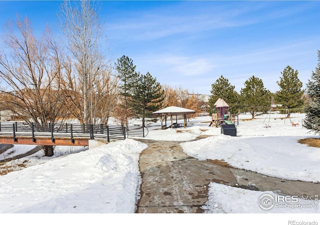 snowy yard featuring a playground