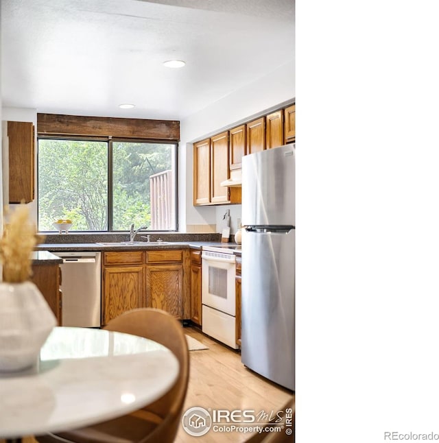 kitchen featuring appliances with stainless steel finishes, sink, and light wood-type flooring