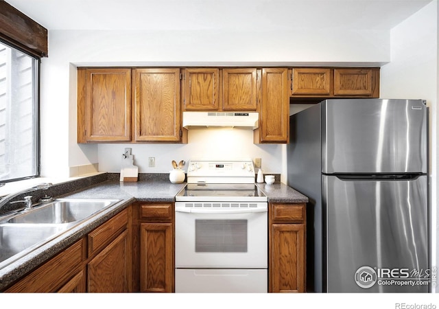 kitchen with white electric stove, plenty of natural light, sink, and stainless steel fridge