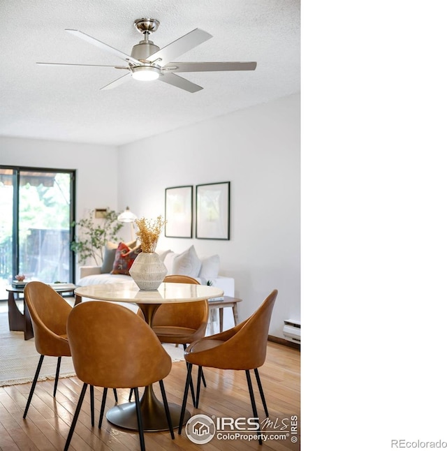 dining area with baseboard heating, ceiling fan, light hardwood / wood-style floors, and a textured ceiling