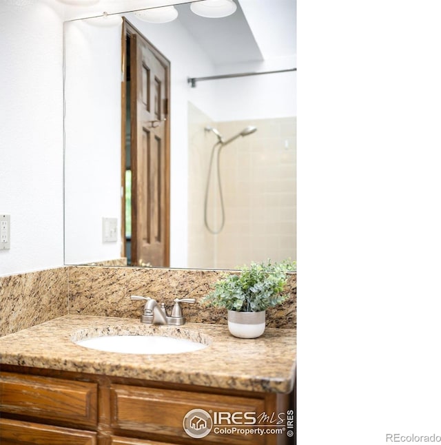 bathroom with a shower and vanity