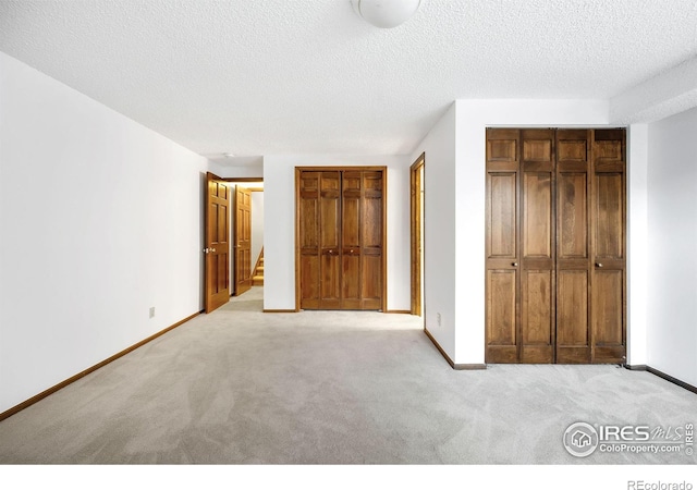 unfurnished bedroom with light carpet and a textured ceiling