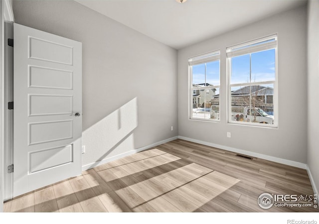 empty room with light hardwood / wood-style flooring