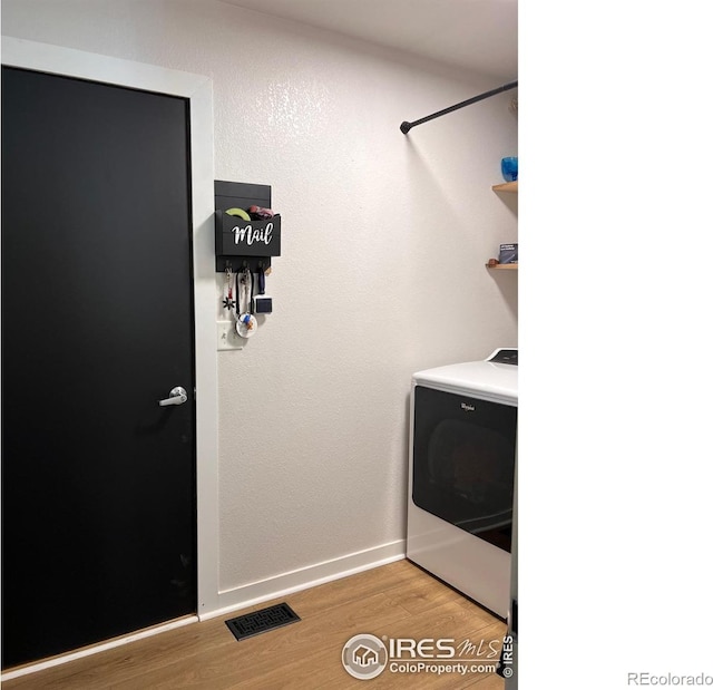 washroom with washer / dryer and light hardwood / wood-style flooring