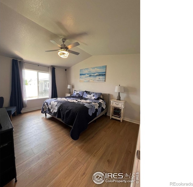 bedroom featuring lofted ceiling, hardwood / wood-style floors, a textured ceiling, and ceiling fan