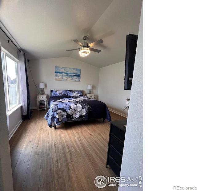 bedroom with hardwood / wood-style flooring, ceiling fan, and lofted ceiling