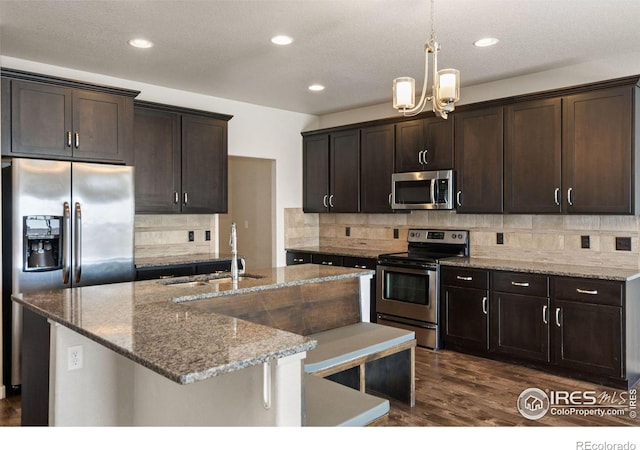 kitchen featuring dark brown cabinetry, sink, backsplash, and appliances with stainless steel finishes