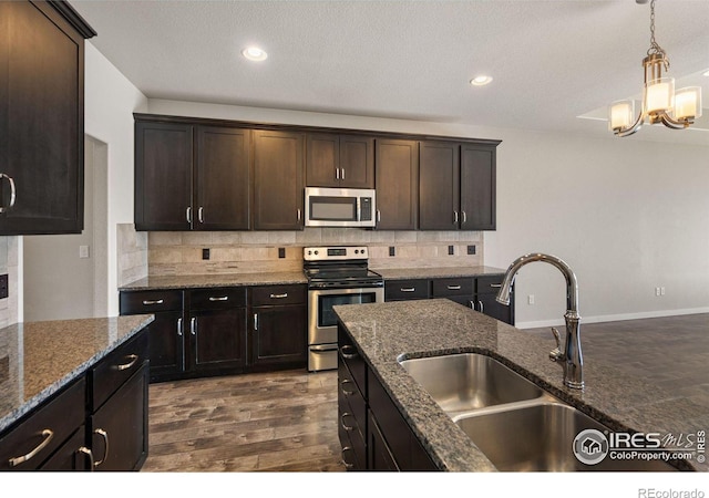 kitchen featuring appliances with stainless steel finishes, dark brown cabinets, sink, and decorative backsplash