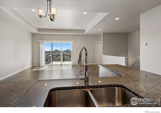 kitchen featuring pendant lighting, a tray ceiling, and sink