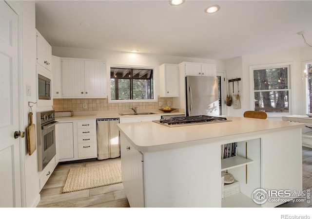 kitchen with white cabinetry, sink, a kitchen island, and appliances with stainless steel finishes