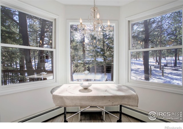 dining area with a baseboard radiator, a healthy amount of sunlight, and a chandelier