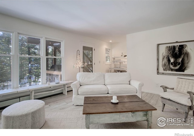 living room with a baseboard heating unit and light hardwood / wood-style floors