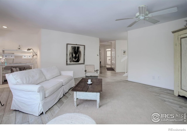 living room featuring ceiling fan and light hardwood / wood-style floors