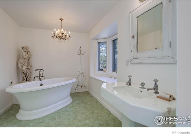 bathroom featuring a chandelier, sink, and a tub