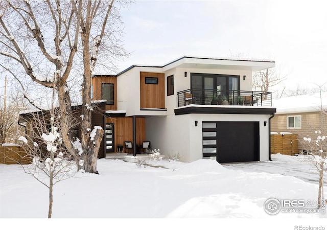 view of front of property featuring a garage and a balcony