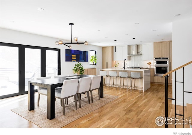 dining area with an inviting chandelier and light hardwood / wood-style floors