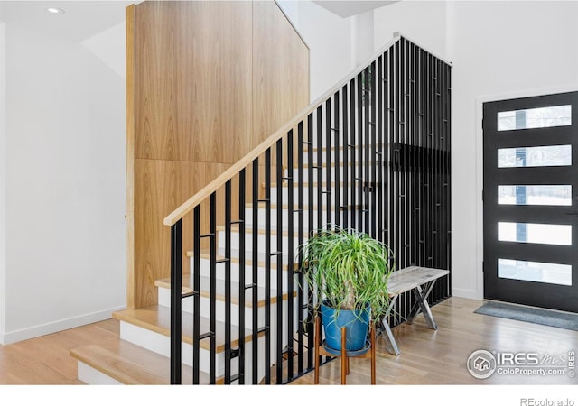 stairway featuring lofted ceiling and wood-type flooring