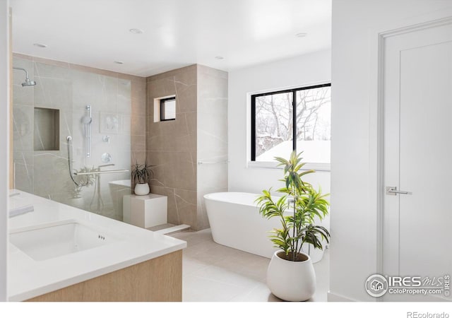 bathroom with vanity, tile patterned flooring, shower with separate bathtub, and tile walls