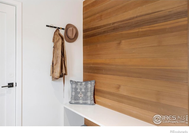 mudroom featuring wood walls