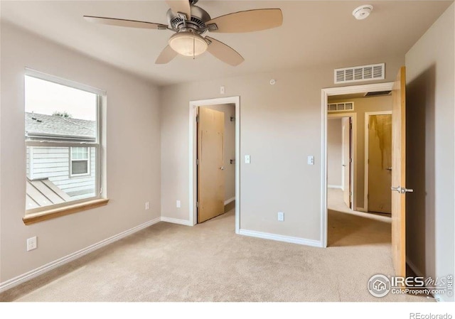 unfurnished bedroom with light colored carpet and ceiling fan