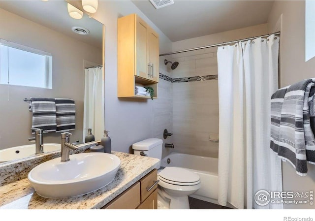 full bathroom featuring shower / tub combo with curtain, vanity, and toilet