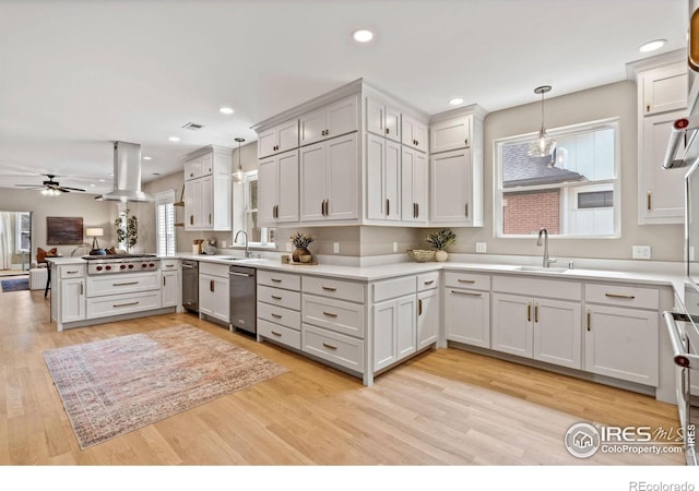 119 N Shields St, Fort Collins, CO 80521 - kitchen with sink, white cabinetry, island range hood, decorative light fixtures, and kitchen peninsula