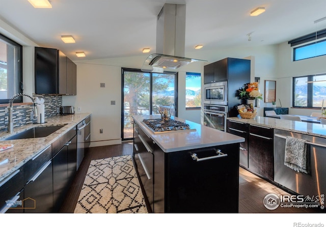 kitchen with sink, island range hood, a center island, stainless steel appliances, and backsplash