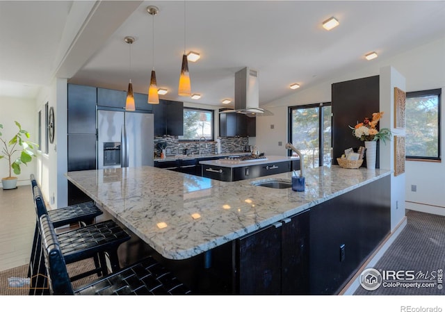 kitchen featuring pendant lighting, a kitchen breakfast bar, stainless steel fridge with ice dispenser, and light stone counters