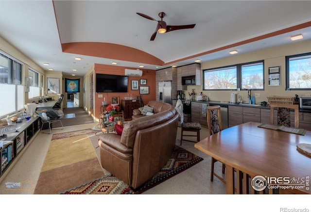 living room with vaulted ceiling, a wall mounted air conditioner, and ceiling fan