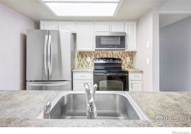 kitchen with white cabinetry, stainless steel appliances, sink, and backsplash