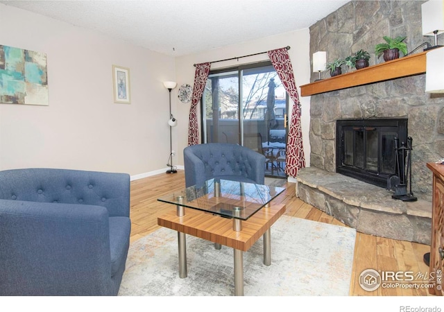 living room with hardwood / wood-style floors, a fireplace, and a textured ceiling