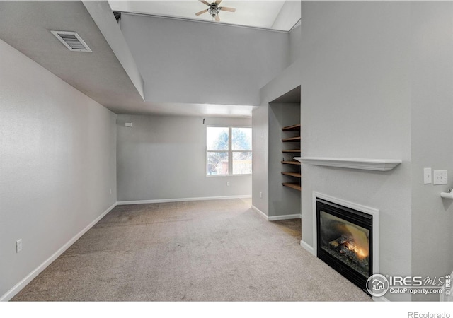 unfurnished living room featuring ceiling fan and light carpet