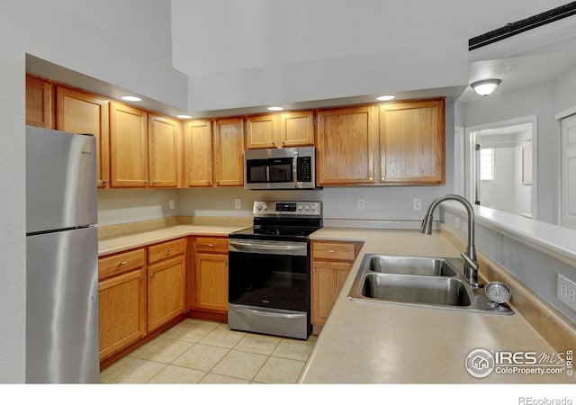 kitchen featuring light tile patterned flooring, appliances with stainless steel finishes, and sink