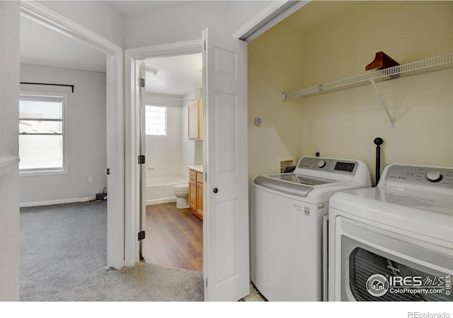 clothes washing area with light colored carpet and washer and dryer