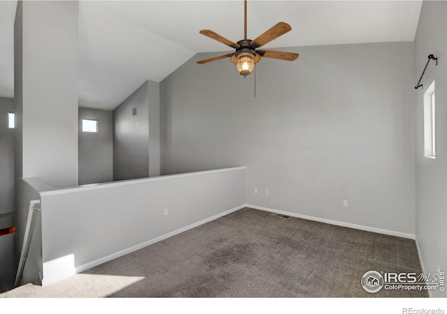 carpeted spare room featuring lofted ceiling and ceiling fan