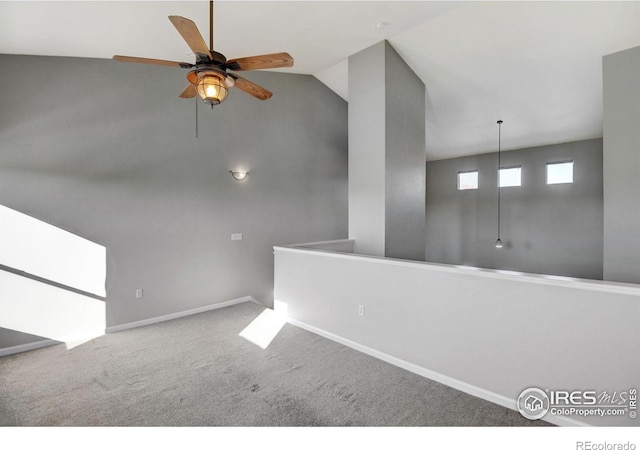 empty room featuring ceiling fan, lofted ceiling, and carpet flooring