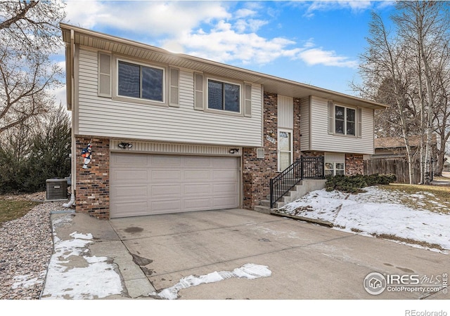 split foyer home featuring a garage and central AC