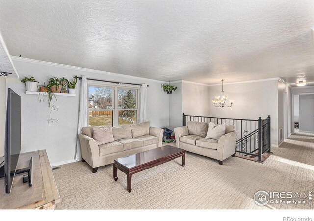 living room with an inviting chandelier, ornamental molding, light colored carpet, and a textured ceiling