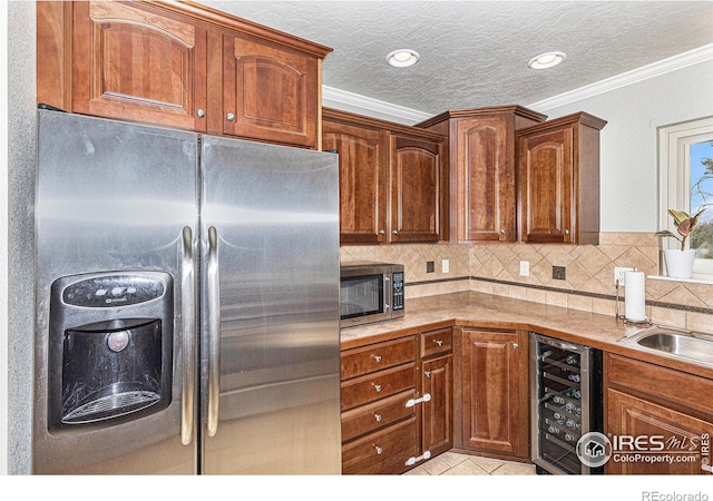 kitchen with stainless steel appliances, wine cooler, tasteful backsplash, ornamental molding, and a textured ceiling