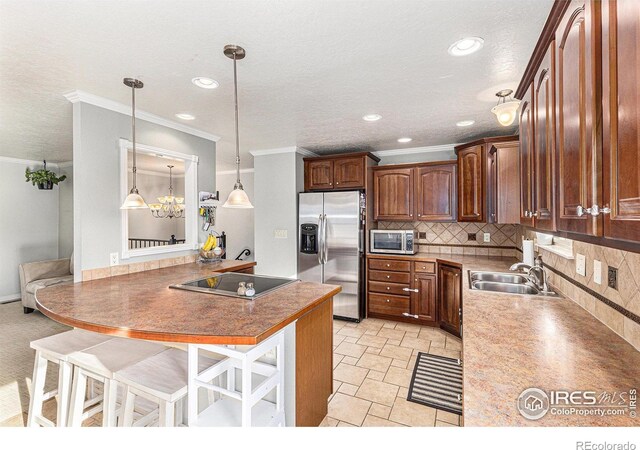 kitchen with a kitchen bar, sink, decorative light fixtures, stainless steel appliances, and backsplash