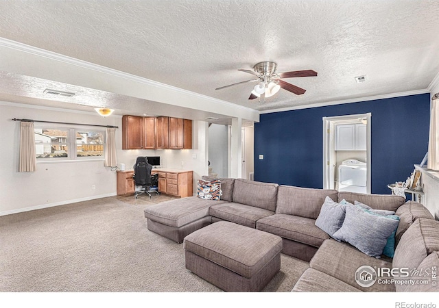 carpeted living room with washer / dryer, built in desk, a textured ceiling, ornamental molding, and ceiling fan